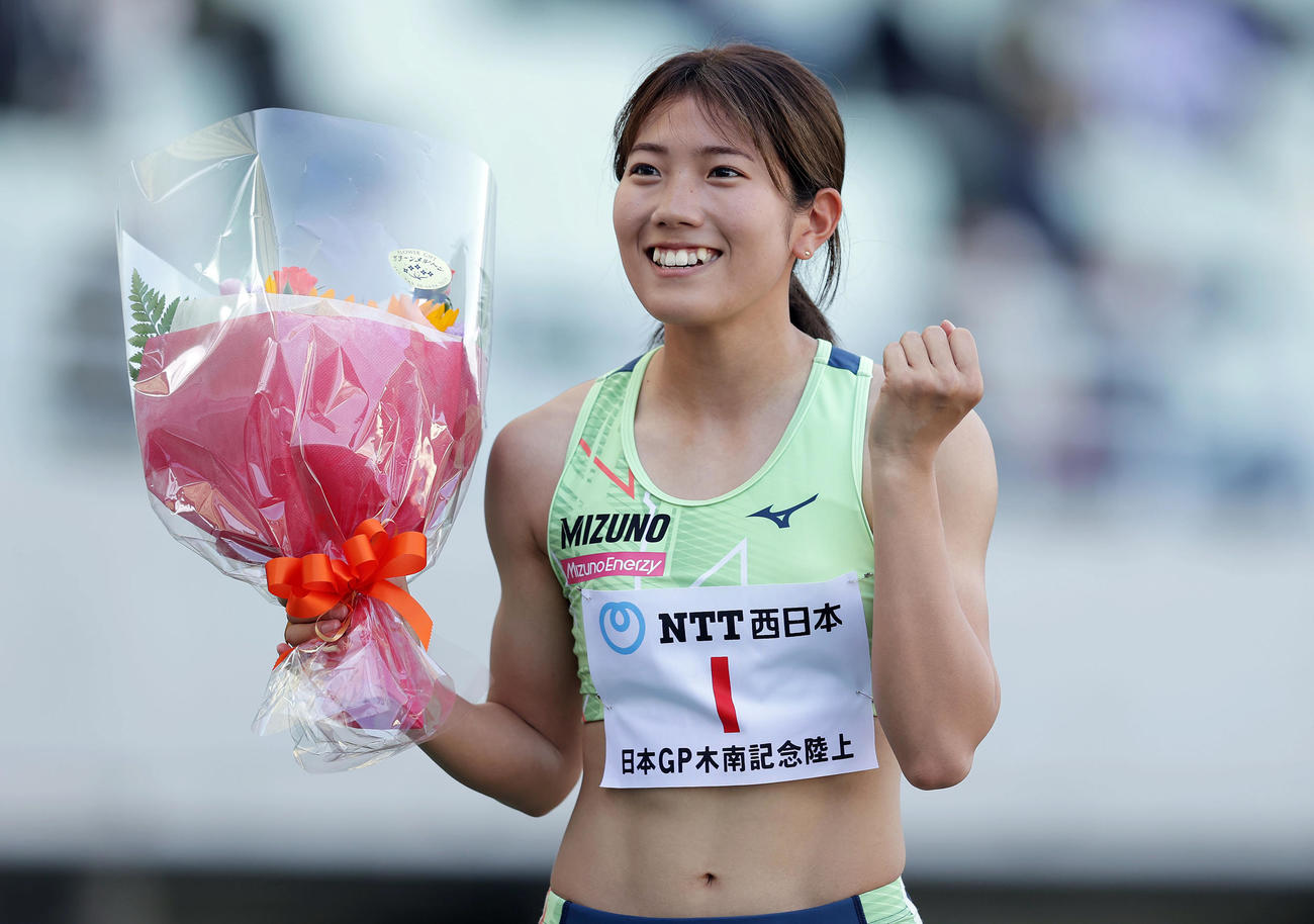 24秒15で優勝し、花束を手に笑顔を見せる児玉（撮影・前田充）