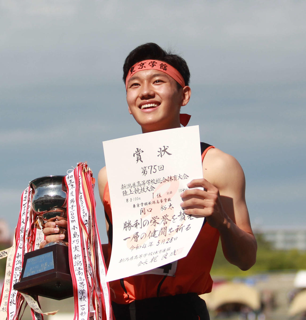 表彰台で笑顔の100メートル優勝の東京学館新潟・関口