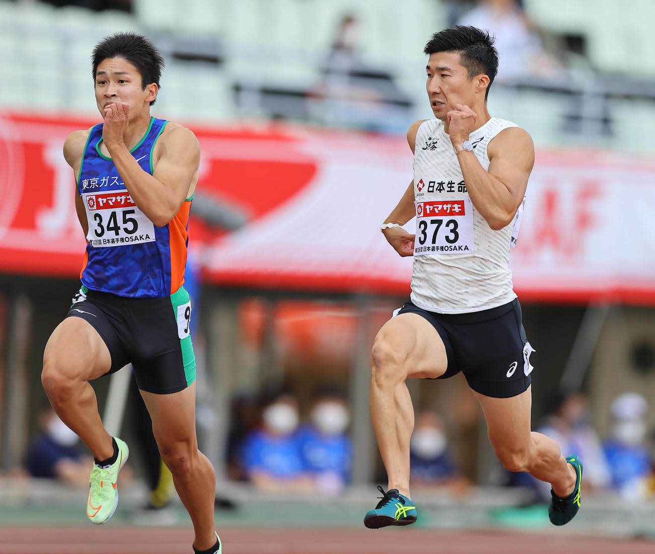 男子100メートル予選、予選で力走する桐生（右）は走りながら伊藤をちらっと見る（撮影・垰建太）