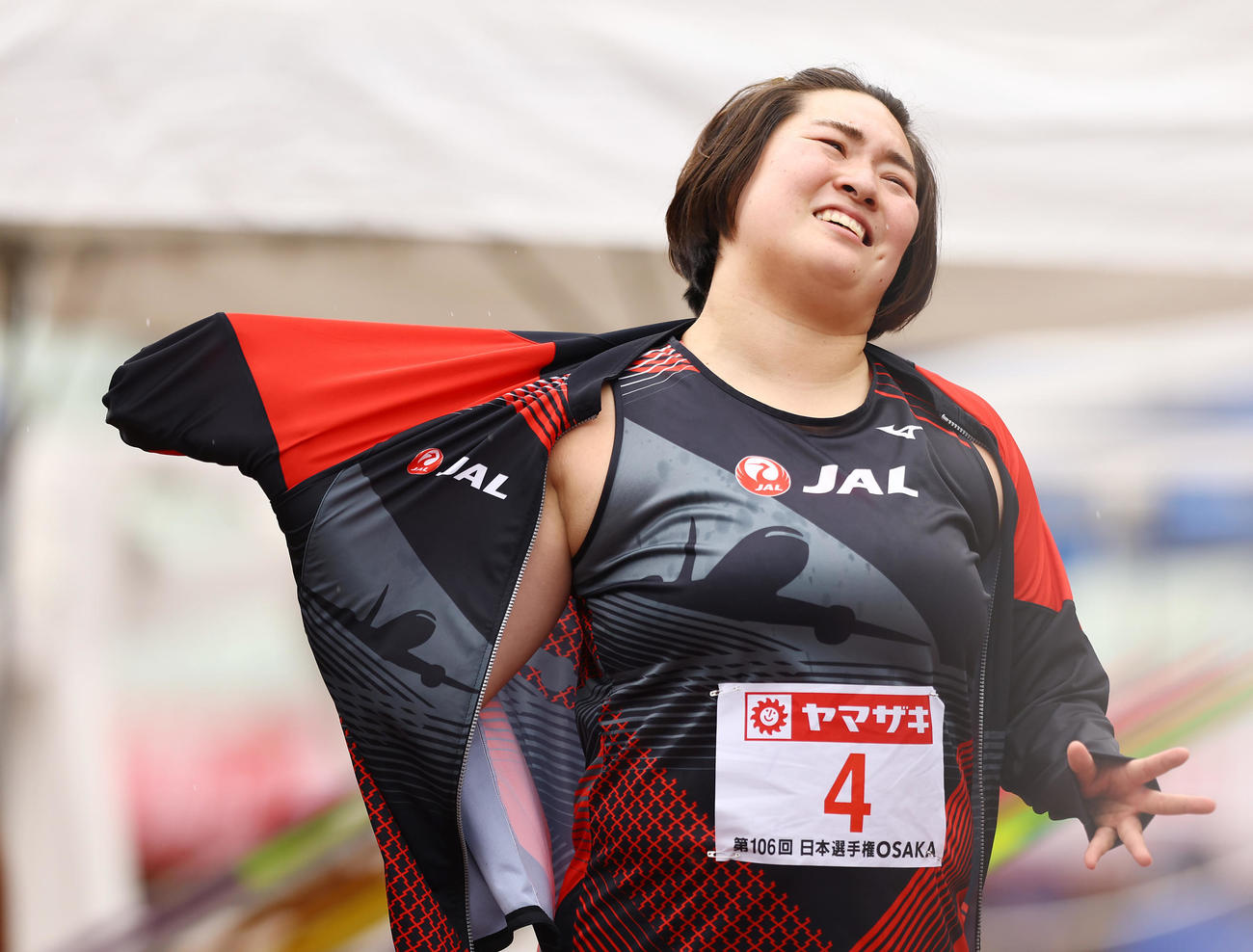 女子やり投げ決勝、1投目を終えジャージーが着ようとするもなかなか袖が通らなく苦笑いの北口（撮影・垰建太）