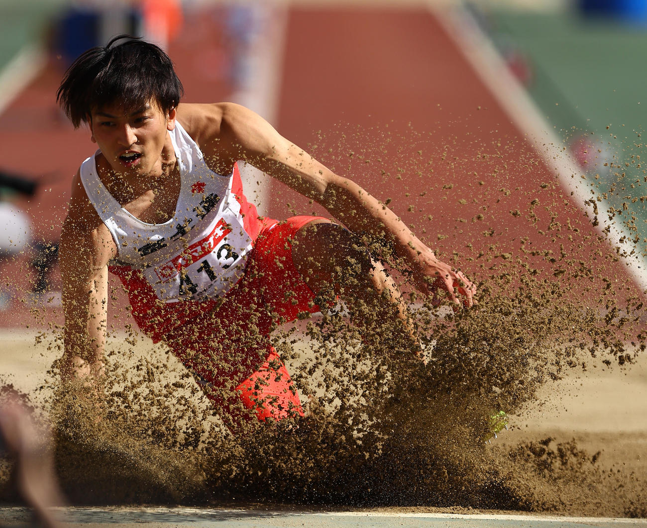 男子走り幅跳び決勝、高い跳躍を見せ砂を巻き上げ着地する橋岡（撮影・垰建太）