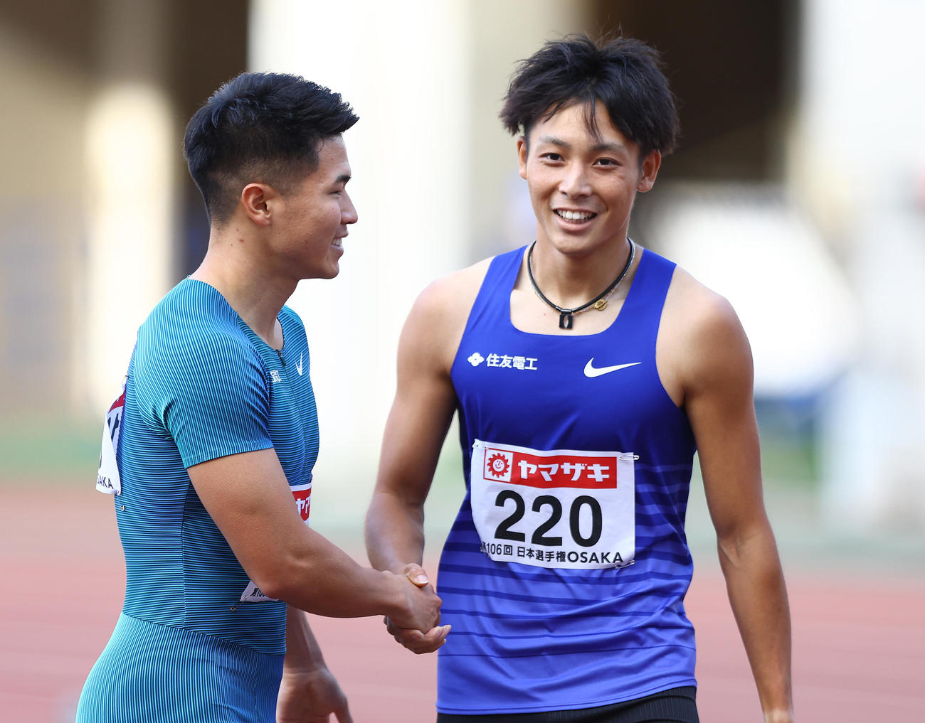 男子200メートル決勝、1位でゴールした上山（右）と笑顔で握手を交わす小池（撮影・垰建太）