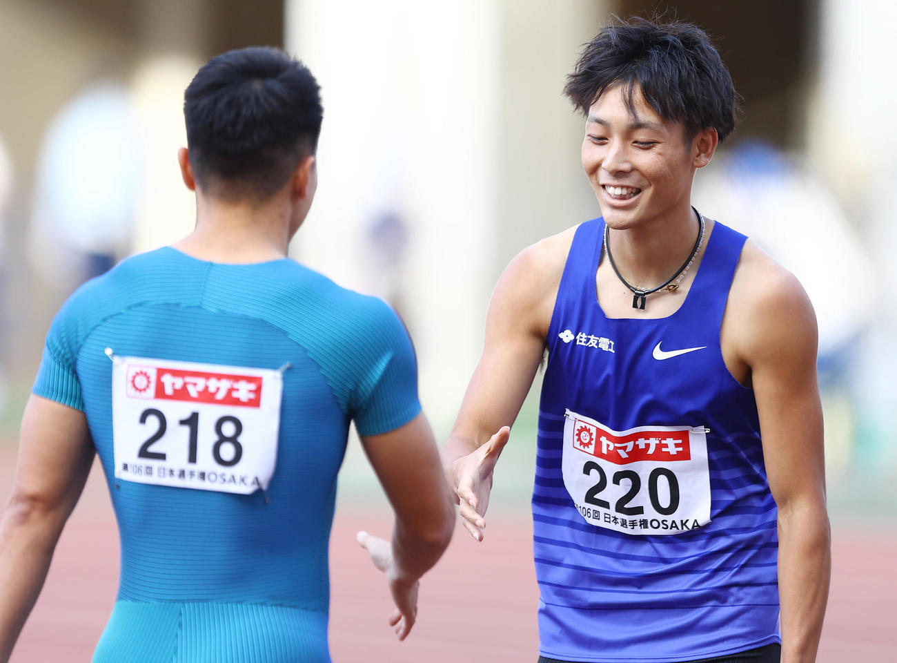 男子200メートル決勝、1位でゴールした上山（右）は小池と笑顔で握手を交わす（撮影・垰建太）