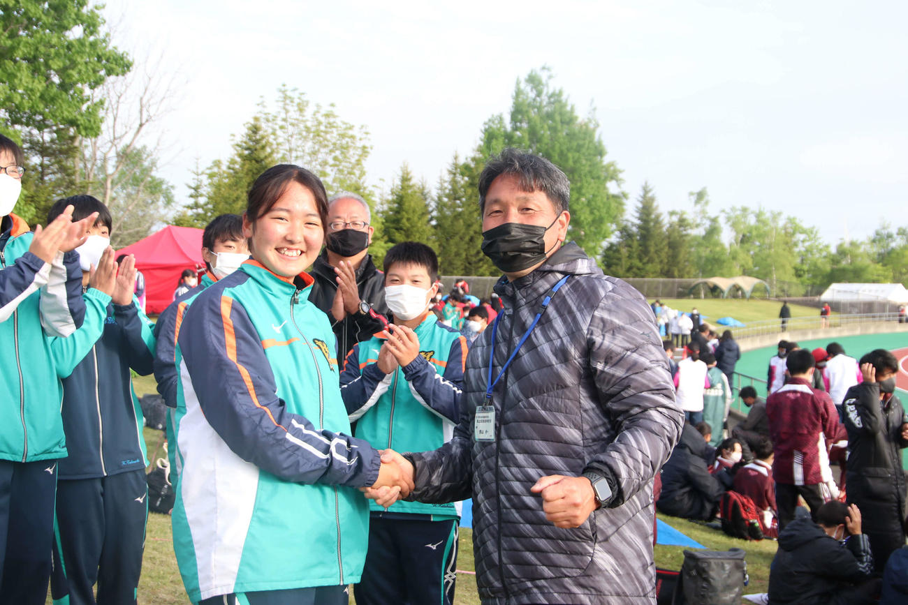 女子円盤投げ決勝　優勝を飾り西山監督（右）と笑顔で握手を交わす幕別清陵・川村（撮影・山崎純一）