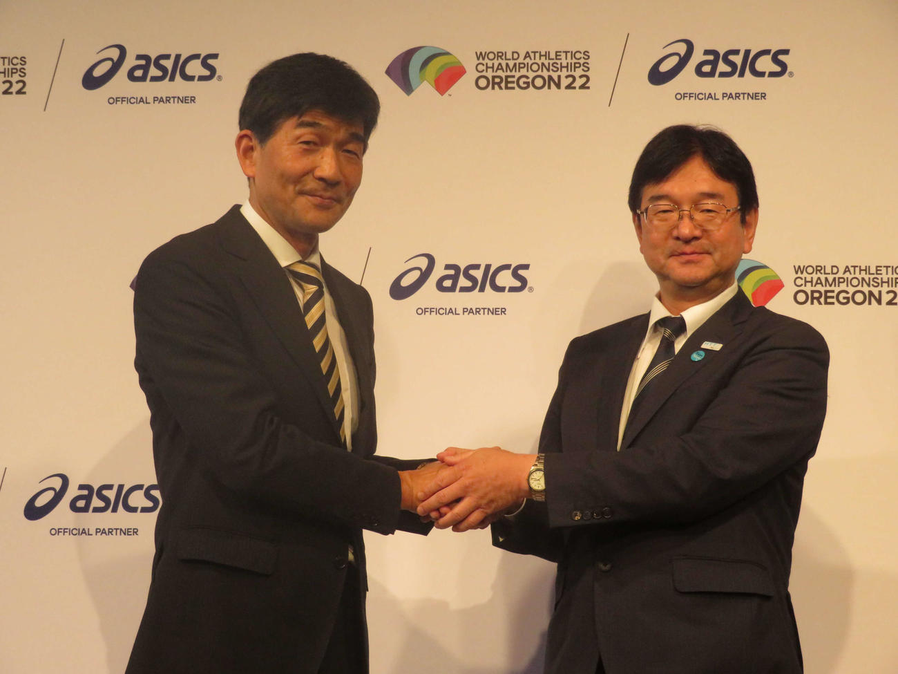 2025年世界選手権が東京都で開催することが決まり、握手を交わす日本陸連の尾県貢会長（左）と東京都の潮田勉副知事