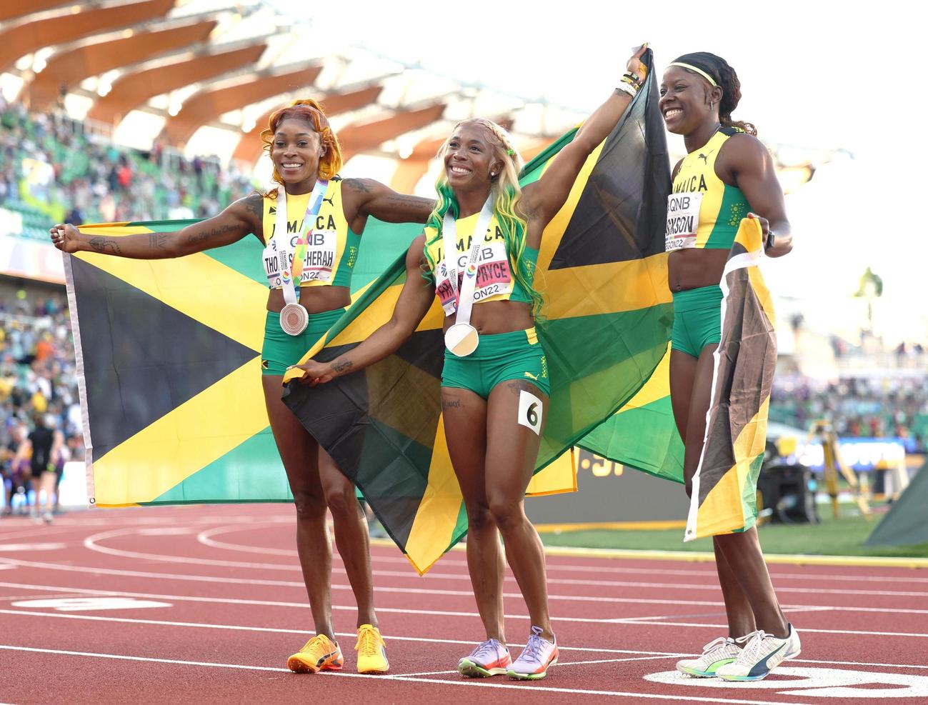 女子100 メートル 決勝を終え笑顔を見せるジャマイカ勢。左から3位のエレーン・トンプソンヘラ、優勝のシェリーアン・フレーザープライス、2位のシェリカ・ジャクソン＝ユージン（代表撮影・共同）