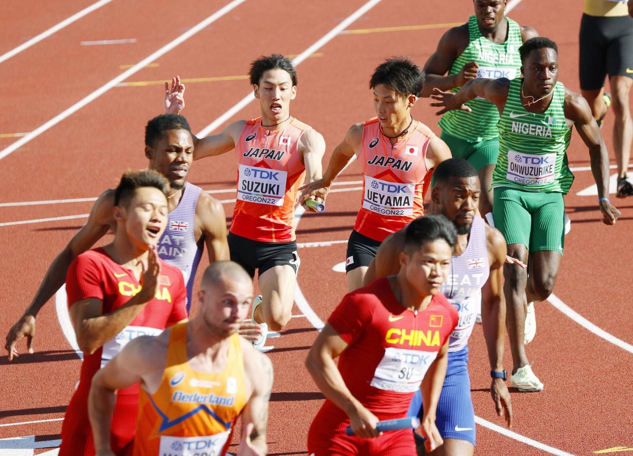 男子400メートルリレー予選　第3走者の上山紘輝（中央右）にバトンを渡す鈴木涼太（代表撮影）