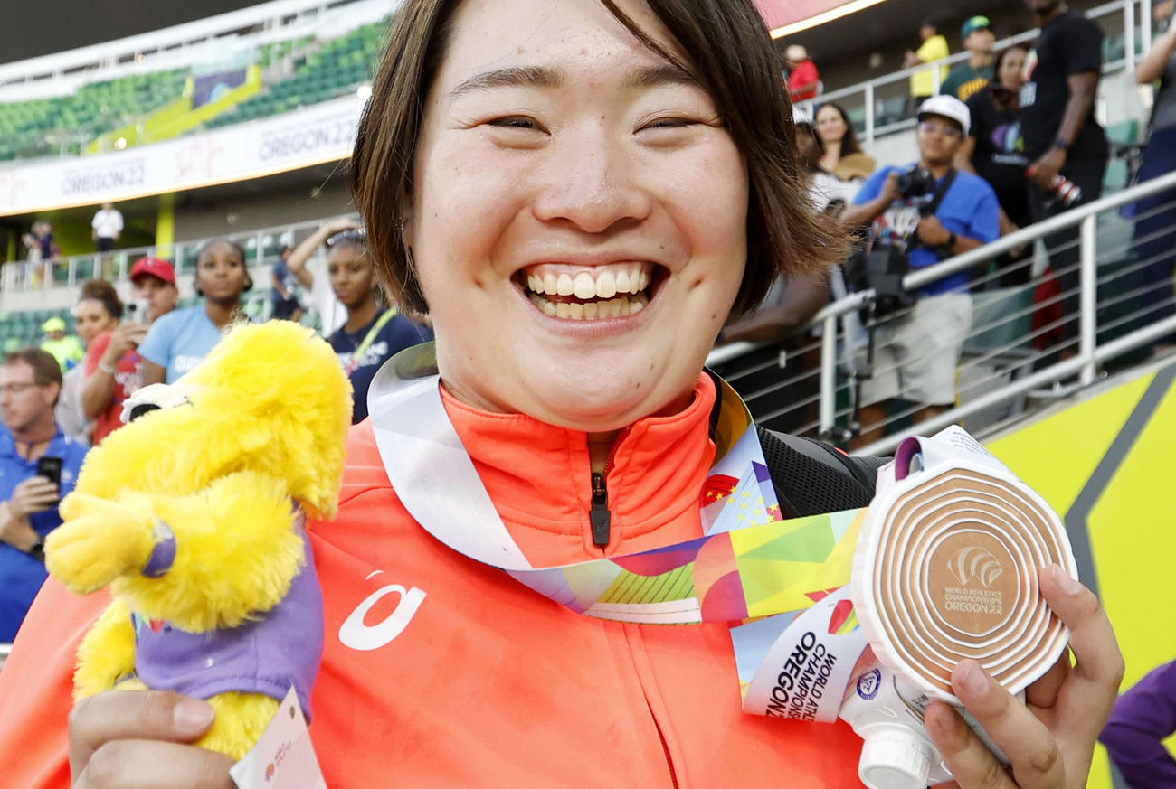 女子やり投げで獲得した銅メダルを手に笑顔の北口榛花（共同）