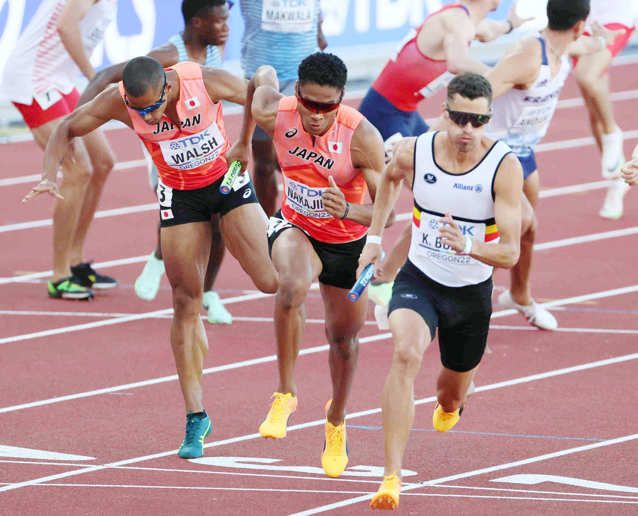 男子1600メートルリレー決勝　第3走者のウォルシュ・ジュリアン（左）からバトンを受けて走り出す中島佑気ジョセフ＝ユージン（代表撮影）