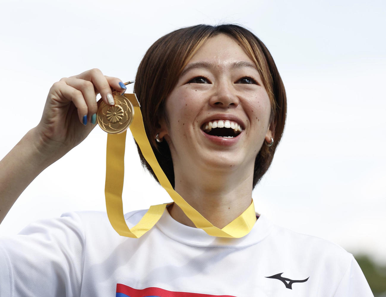 女子200 メートル で優勝し、表彰式で笑顔を見せる青野朱李。100 メートル との2冠を達成した（共同）