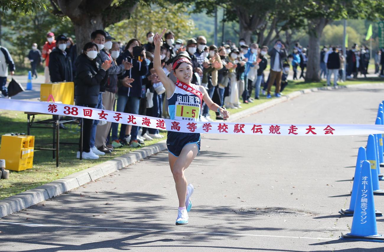 旭川龍谷の5走・山本は、右手で1番ポーズを作ってゴールテープを切る(撮影・中島洋尚)
