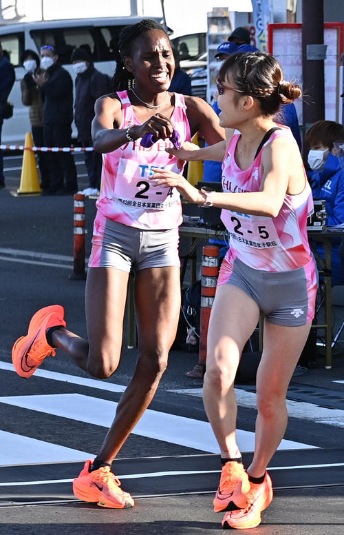 資生堂5区五島（右）に笑顔でたすきをつなぐ4区ジュディ（代表撮影）