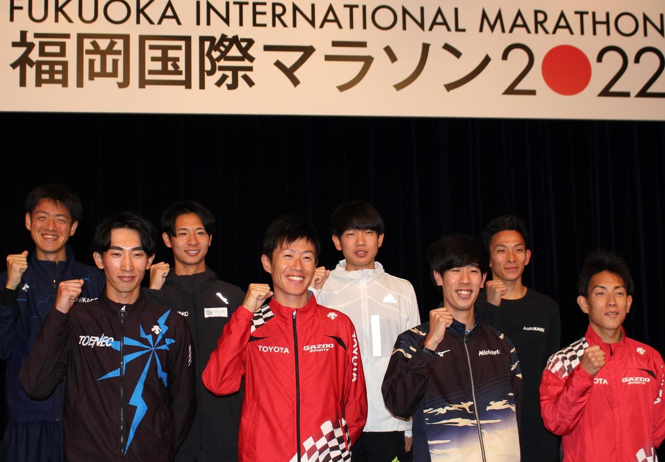 福岡国際マラソンの記者会見に臨み、気合を入れる公務員ランナーの細谷翔馬（後列右から2人目）ら日本人招待選手（撮影・菊川光一）