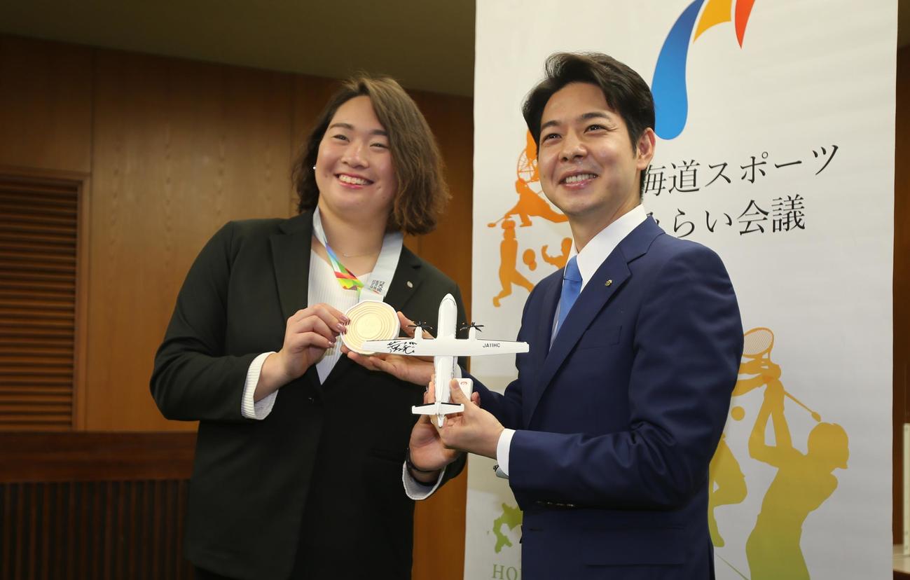 陸上女子やり投げの北口（左）は、鈴木北海道知事と一緒に、世界陸上の銅メダルと所属先JALの飛行機モデルを手に笑顔（撮影・中島洋尚）
