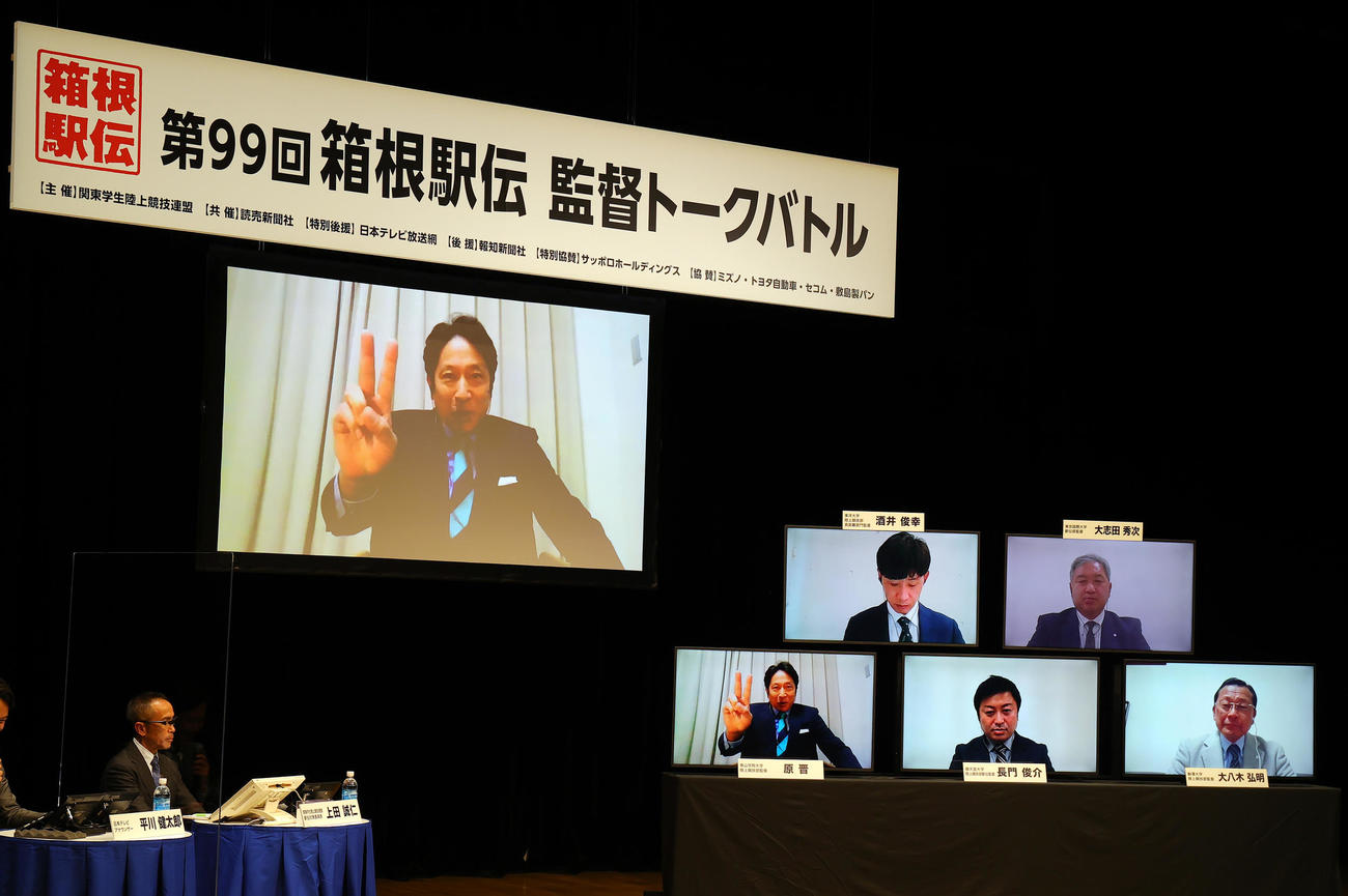 箱根駅伝監督トークバトルで、「ピース大作戦」を宣言する青学大・原監督（左大モニター）。右小モニター下段右から駒大・大八木監督、順大・長門監督、上段右から東京国際大・大志田監督、東洋大・酒井監督（撮影・野上伸悟）
