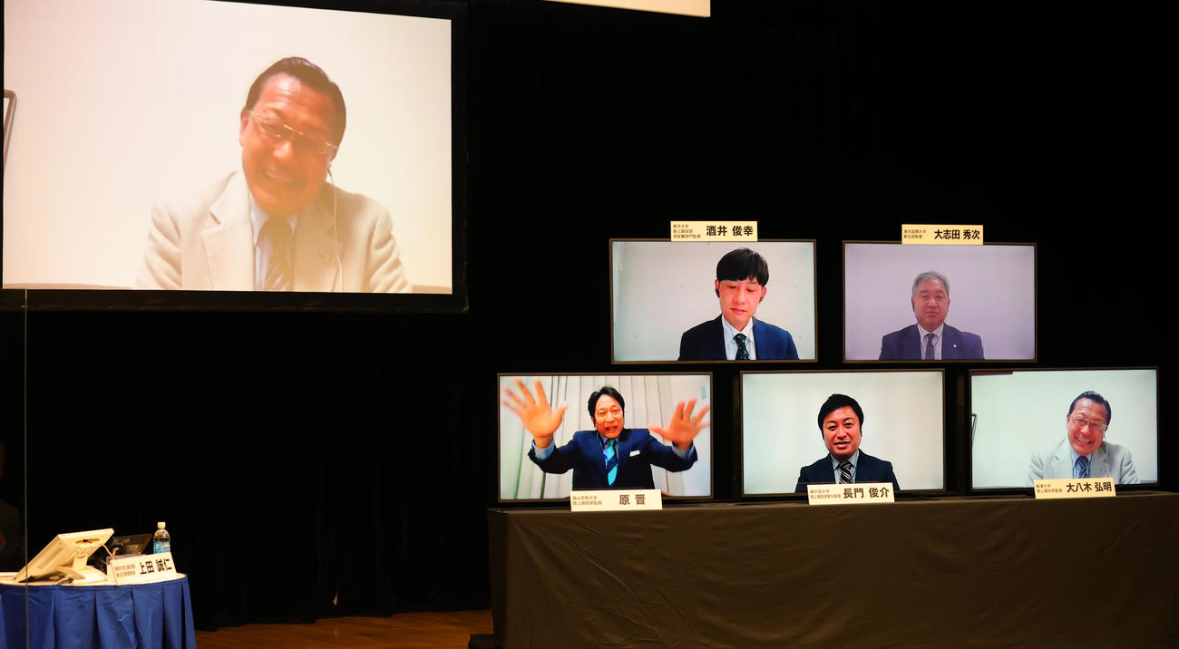箱根駅伝監督トークバトルで笑顔を見せる駒大・大八木監督。右小モニター下段左から青学大・原監督、順大・長門監督、駒大・大八木監督、上段左から東洋大・酒井監督、東京国際大・大志田監督（撮影・野上伸悟）
