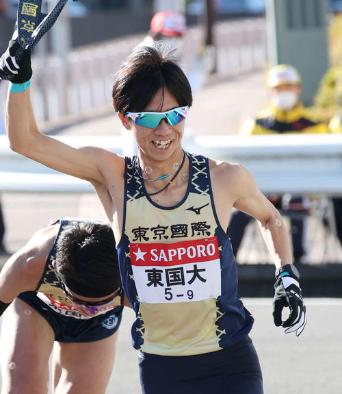 戸塚中継所で東京国際大8区宗像からたすきを受け走り出す9区村松（撮影・宮地輝）