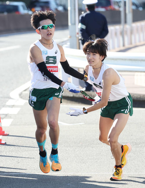 戸塚中継所で専大8区野下（左）は9区南にたすきを渡す（撮影・宮地輝）