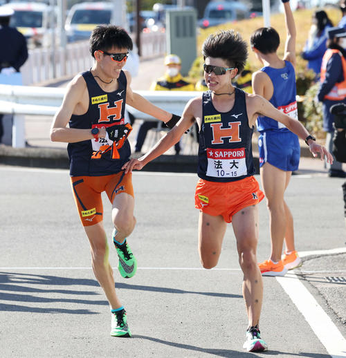 戸塚中継所で法大8区宗像（右）は9区中園にたすきを渡す（撮影・宮地輝）