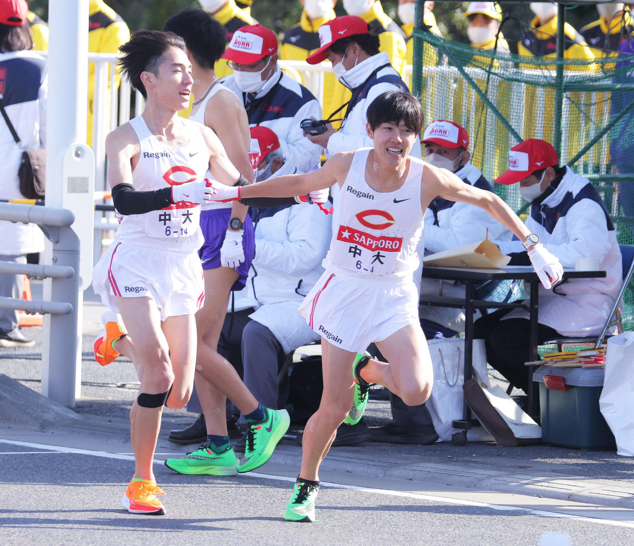 平塚中継所、1位でたすきをつなぐ中大3区中野と4区吉居（撮影・河田真司）