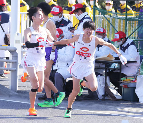 平塚中継所、1位でたすきをつなぐ中大3区中野と4区吉居（撮影・河田真司）
