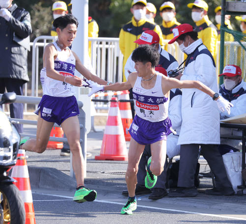 平塚中継所、2位でたすきをつなぐ駒大3区篠原（左）と4区鈴木（撮影・河田真司）