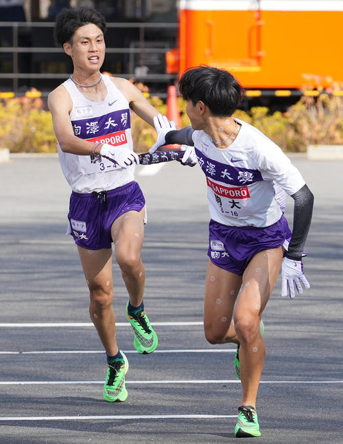 駒大4区鈴木（左）は小田原中継所で5区山川にたすきを渡す（撮影・鈴木みどり）