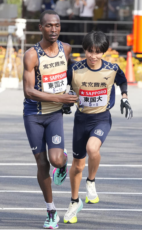 東京国際大4区ヴィンセント（左）は小田原中継所で5区川端にたすきを渡す（撮影・鈴木みどり）