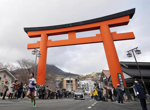 箱根神社の大鳥居をトップで走り抜ける駒大5区山川（撮影・狩俣裕三）