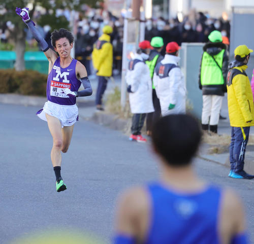 1区トップの明大・富田は、ガッツポーズで鶴見中継所に向かう（撮影・野上伸悟）