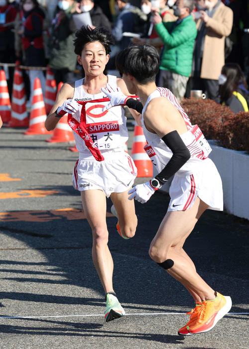 戸塚中継所で中大2区吉居（左）は3区中野にたすきを渡す（撮影・宮地輝）