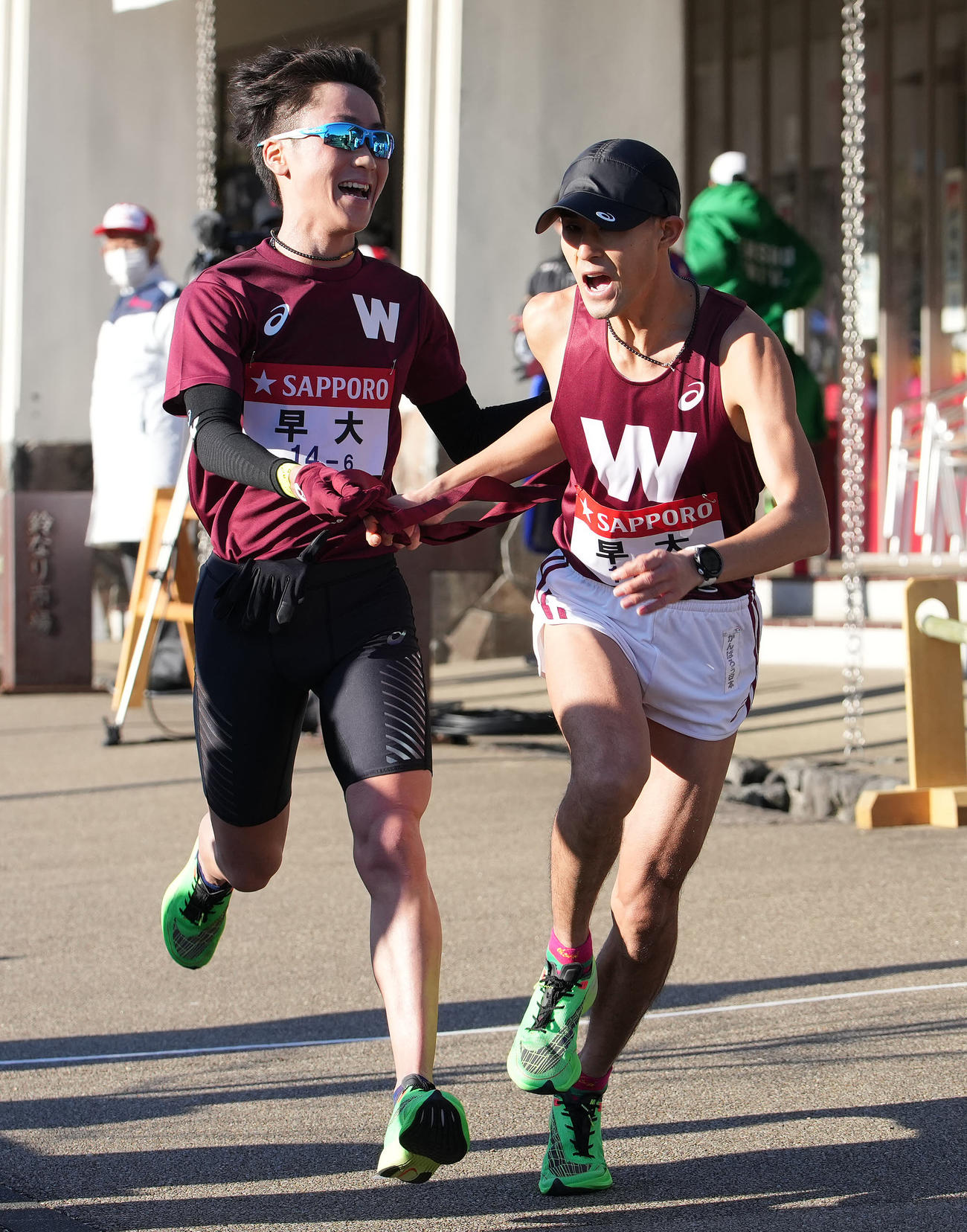 早大6区北村（左）は小田原中継所で7区鈴木にたすきを渡す（撮影・鈴木みどり）