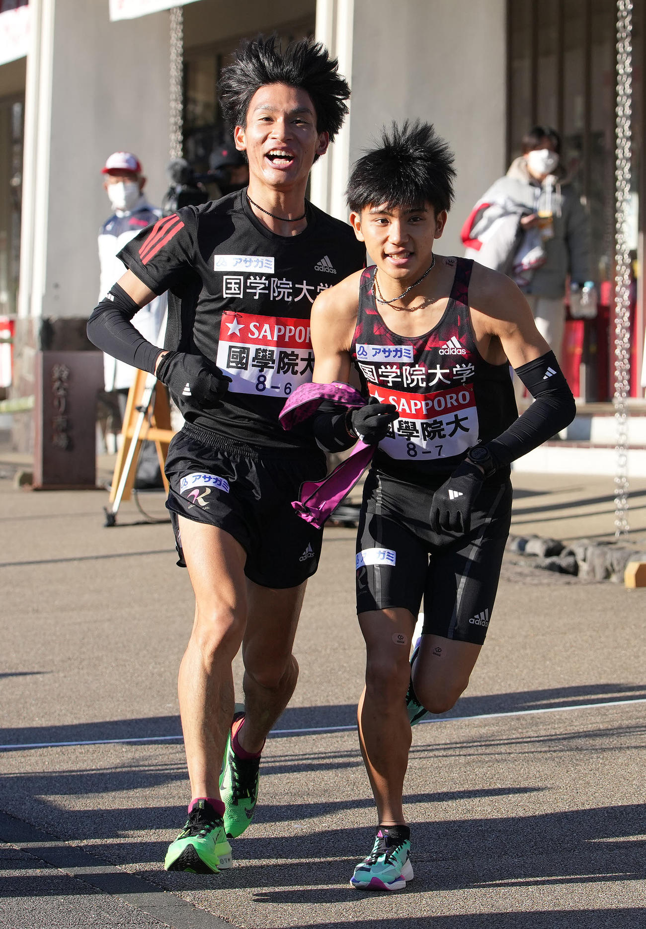 国学院大6区島崎（左）は小田原中継所で7区上原にたすきを渡す（撮影・鈴木みどり）