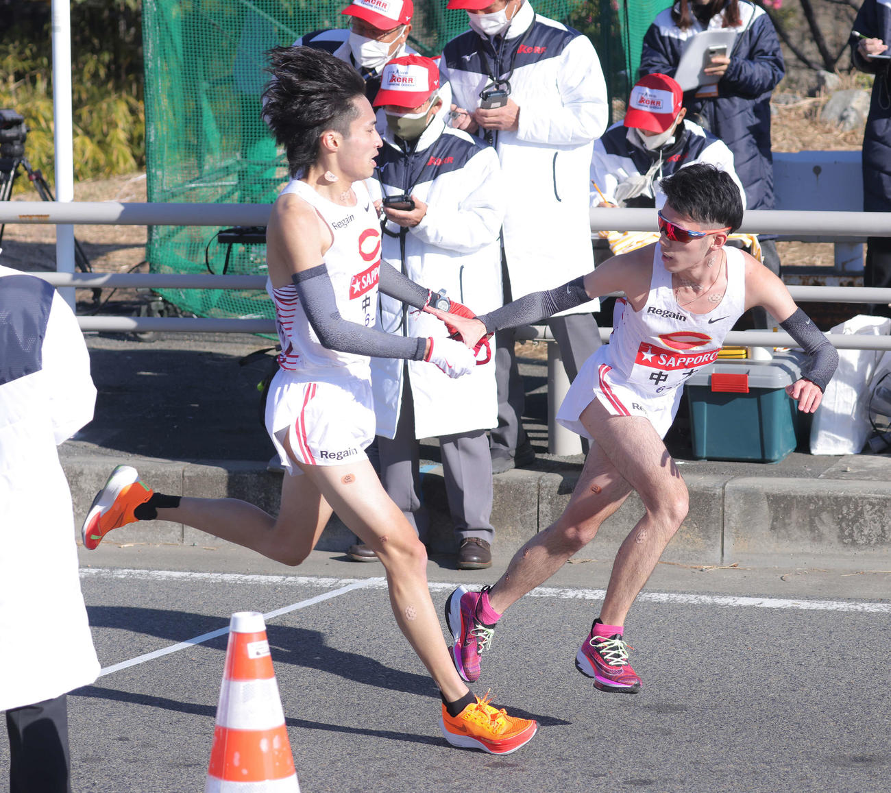 平塚中継所、2位でたすきをつなぐ中大7区千守（左）と8区中沢（撮影・河田真司）