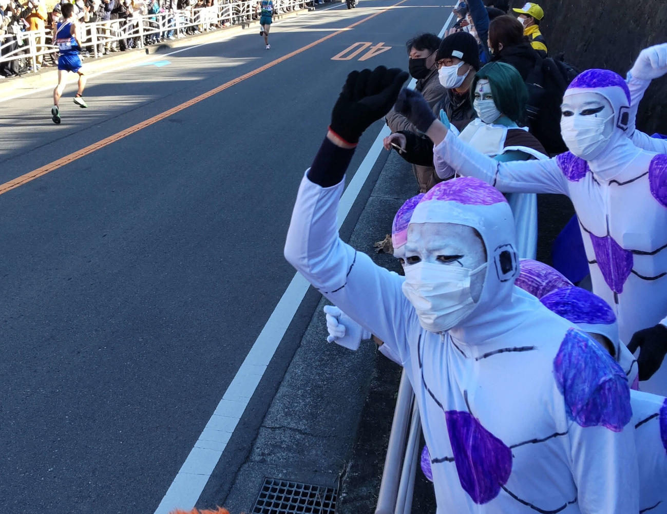 拳を振り上げて駆け抜ける選手全員を応援するフリーザ軍団（撮影・寺沢卓）