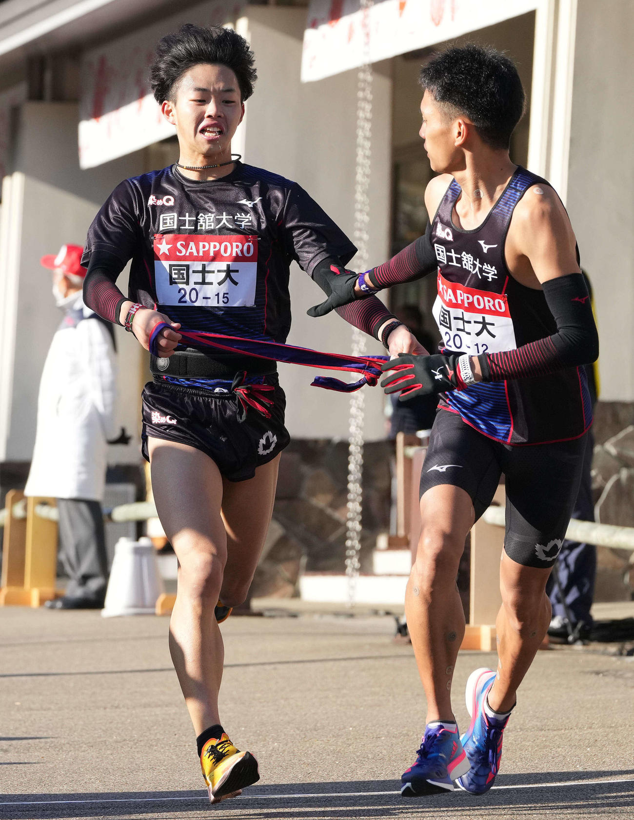 第98回箱根駅伝　国士舘大6区福井大夢（左）は小田原中継所でたすきを渡す（2022年1月3日撮影）