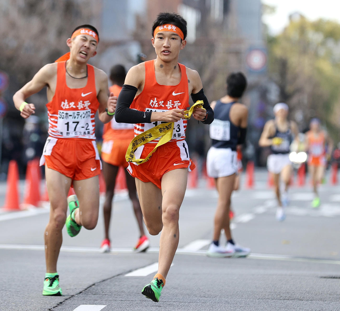 佐久長聖3区吉岡（手前）は2区浜口（左）からたすきを受け走り出す（撮影・上山淳一）