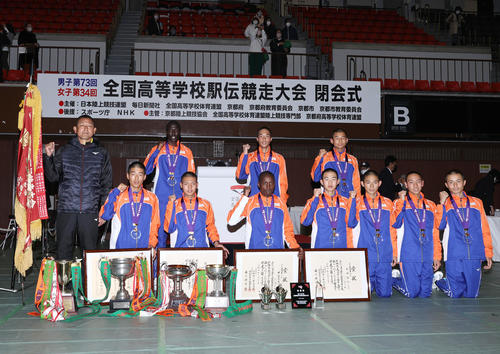 高校駅伝・男子で優勝し、笑顔で記念撮影に納まる倉敷の選手たち。前列左から1区南坂、2区植月、3区サムエル、4区桑田、5区田坂、6区菱田、7区檜垣、後列左は新監督（撮影・上山淳一）