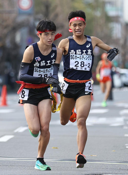西脇工3区藤田（手前）は2区小田（右）からたすきを受け走り出す（撮影・上山淳一）