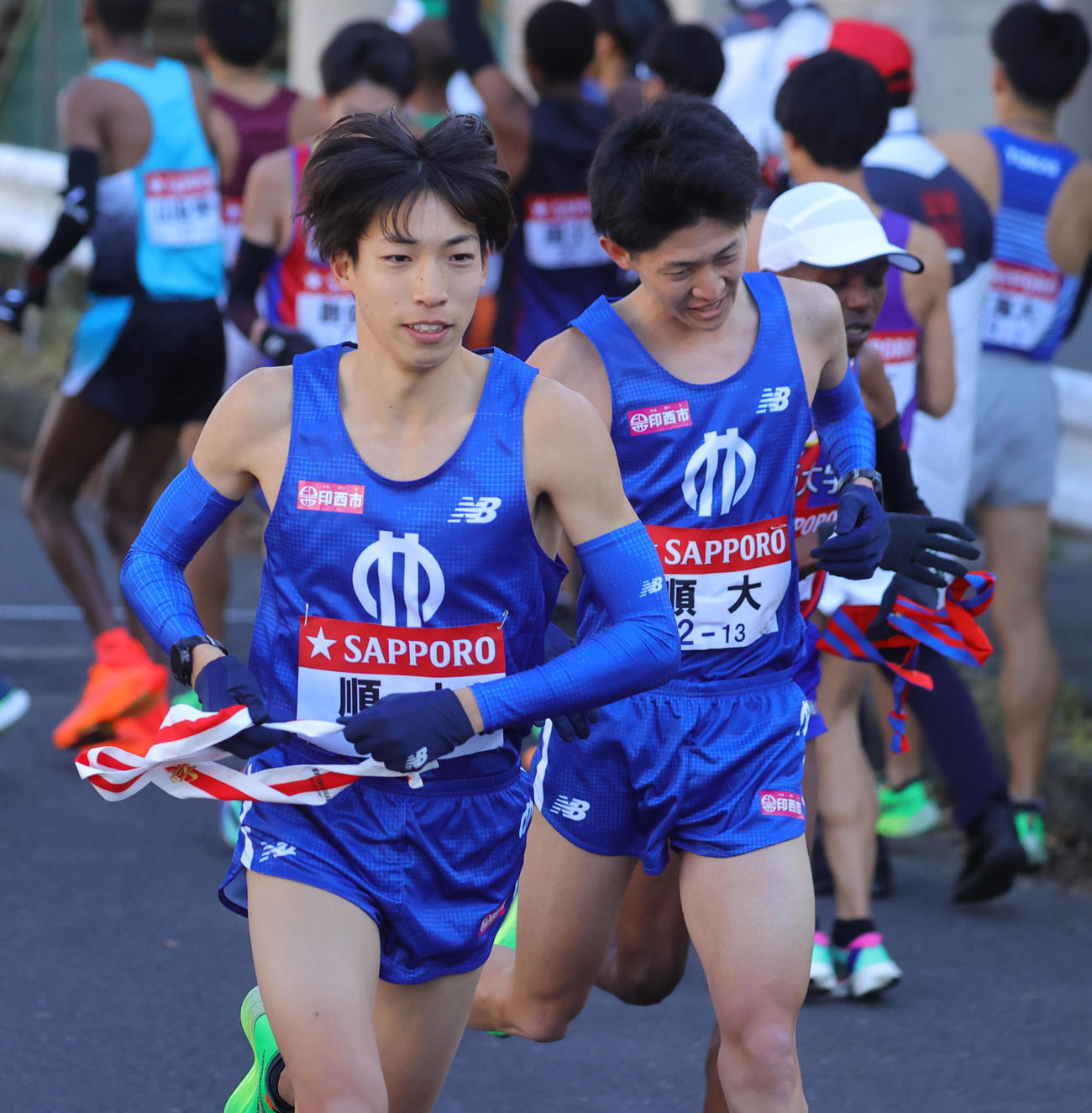 1区野村（後方）からたすきを受け取り力走する順大2区の三浦（撮影・野上伸悟）