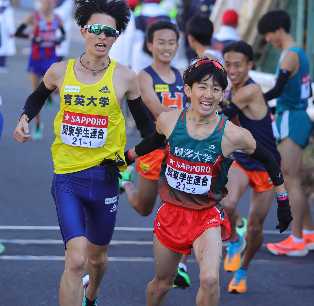1区の育英大・新田（左）からたすきを受け取る2区関東学生連合の麗沢大・工藤（撮影・野上伸悟）