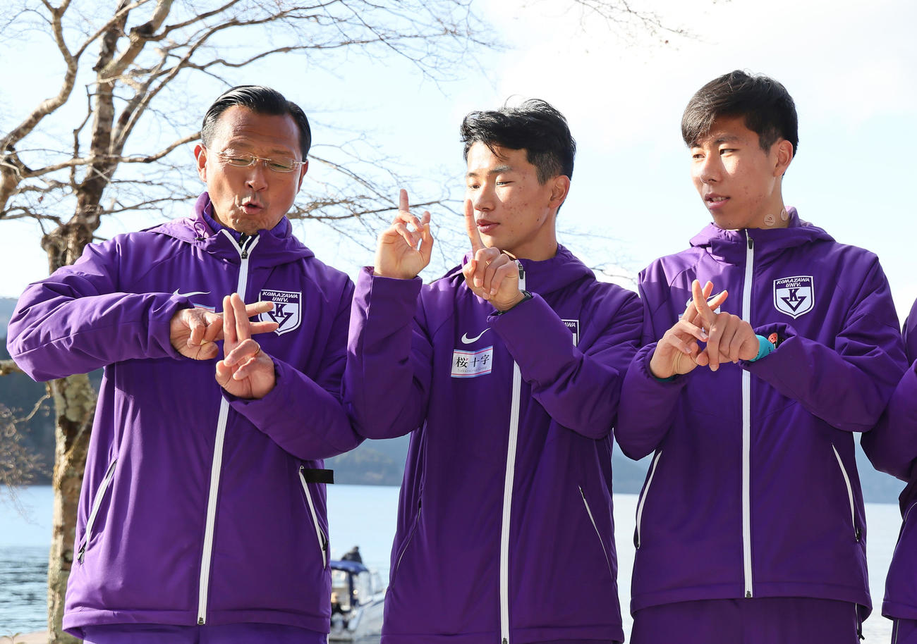 往路優勝し「K」のポーズを考えながら作る駒大の、左から大八木監督、1区円、2区田沢（撮影・足立雅史）