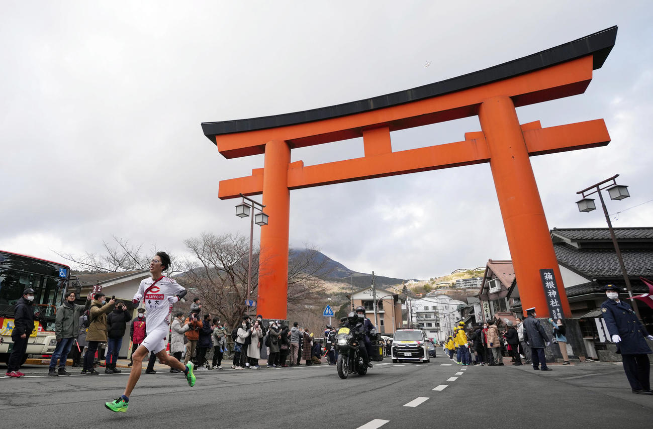 箱根神社の大鳥居を走り抜ける中大5区阿部（撮影・狩俣裕三）