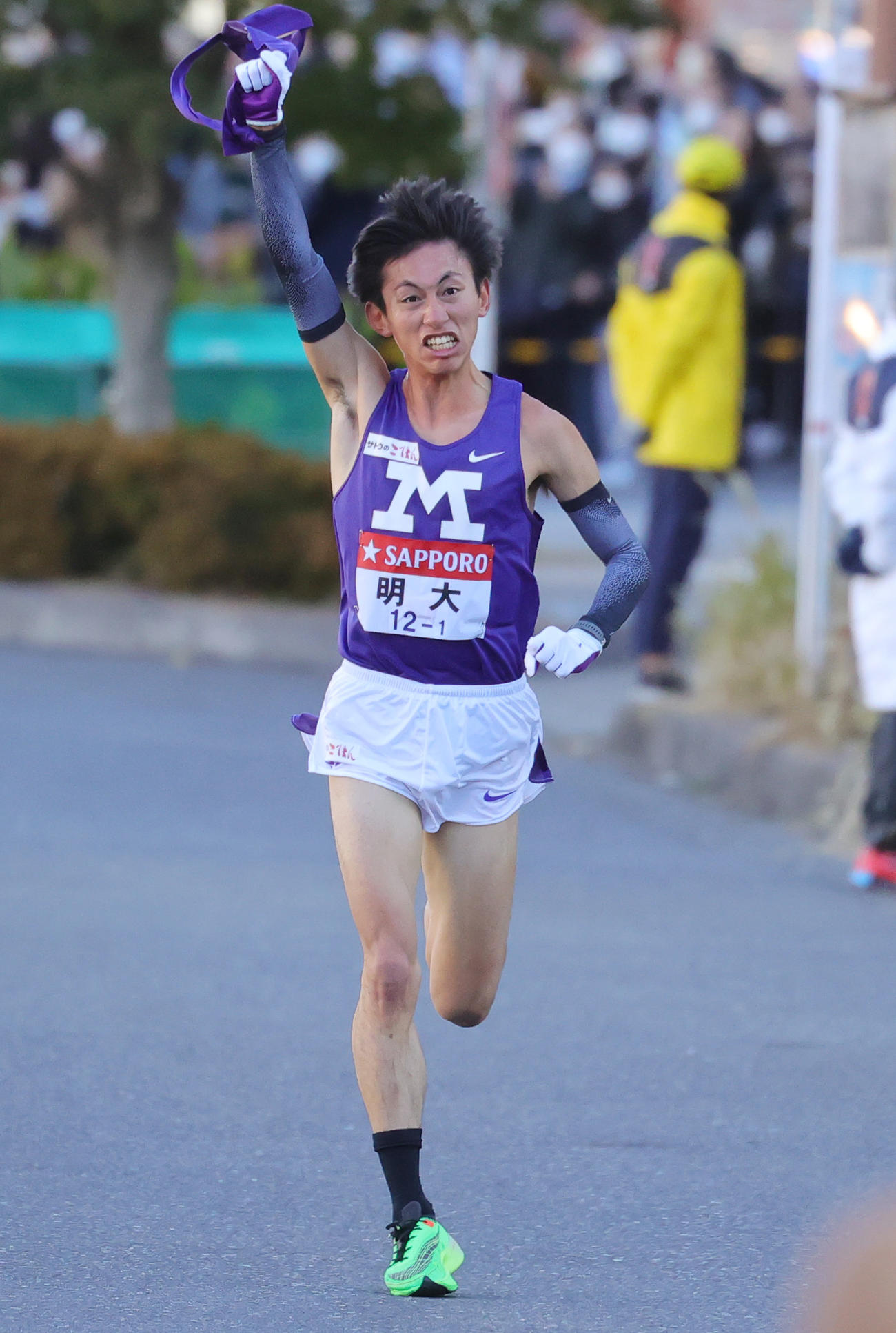 1区トップの明大・富田は、ガッツポーズで鶴見中継所に向かう（撮影・野上伸悟）