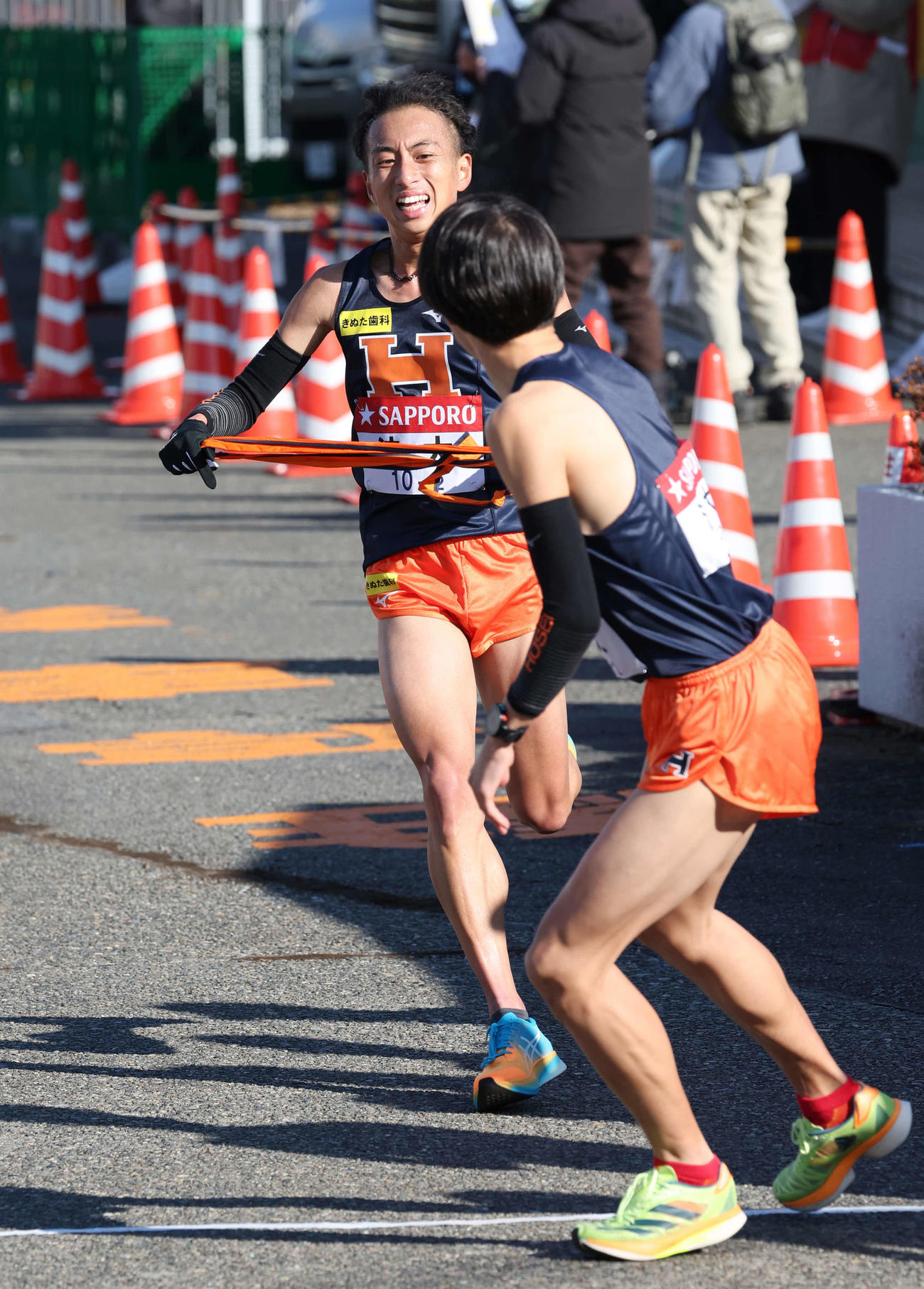 戸塚中継所で法大2区内田（左）は3区川上にたすきを渡す（撮影・宮地輝）