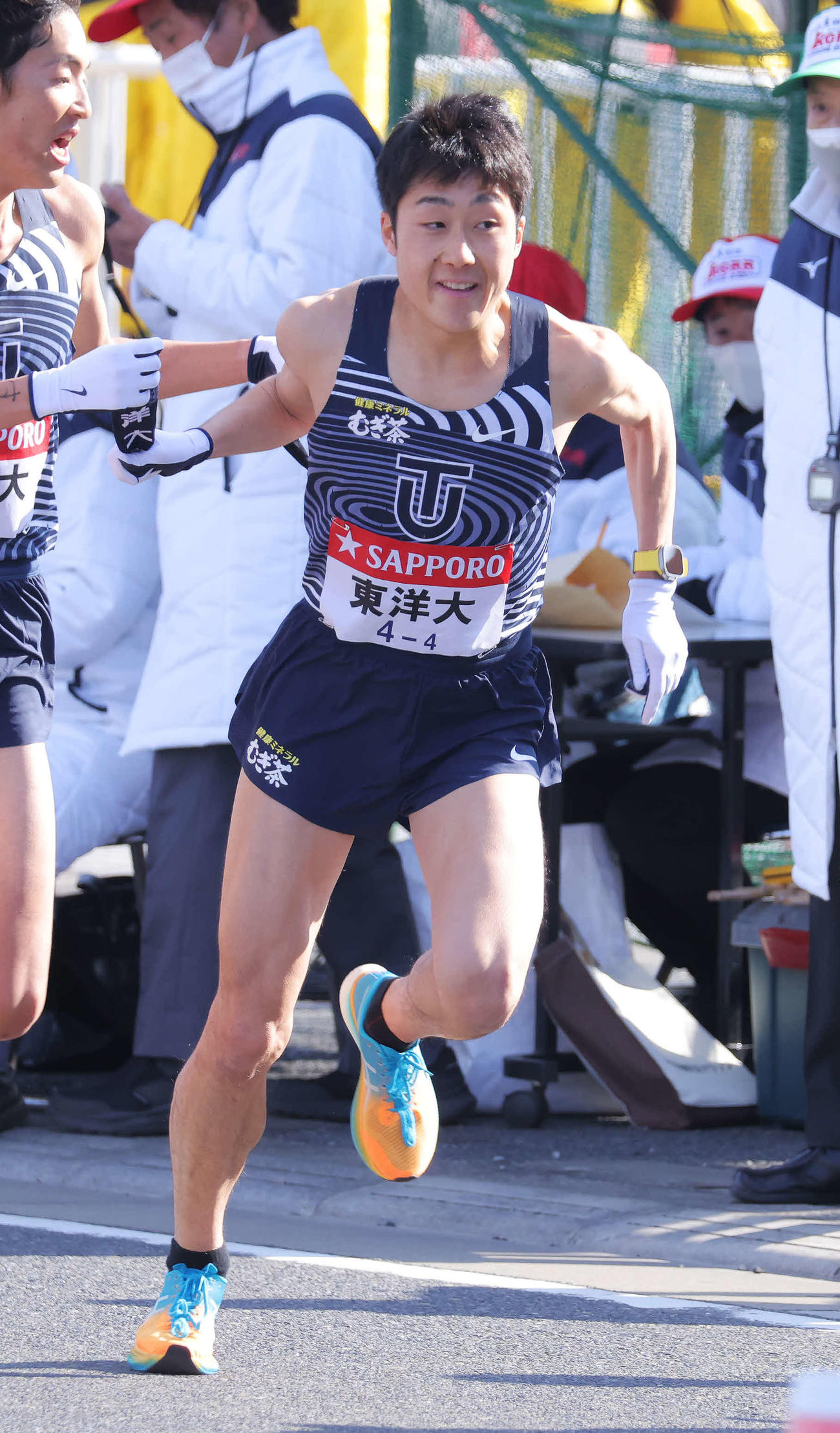 平塚中継所、16位でたすきをつなぐ東洋大3区小林（左）と4区柏（撮影・河田真司）