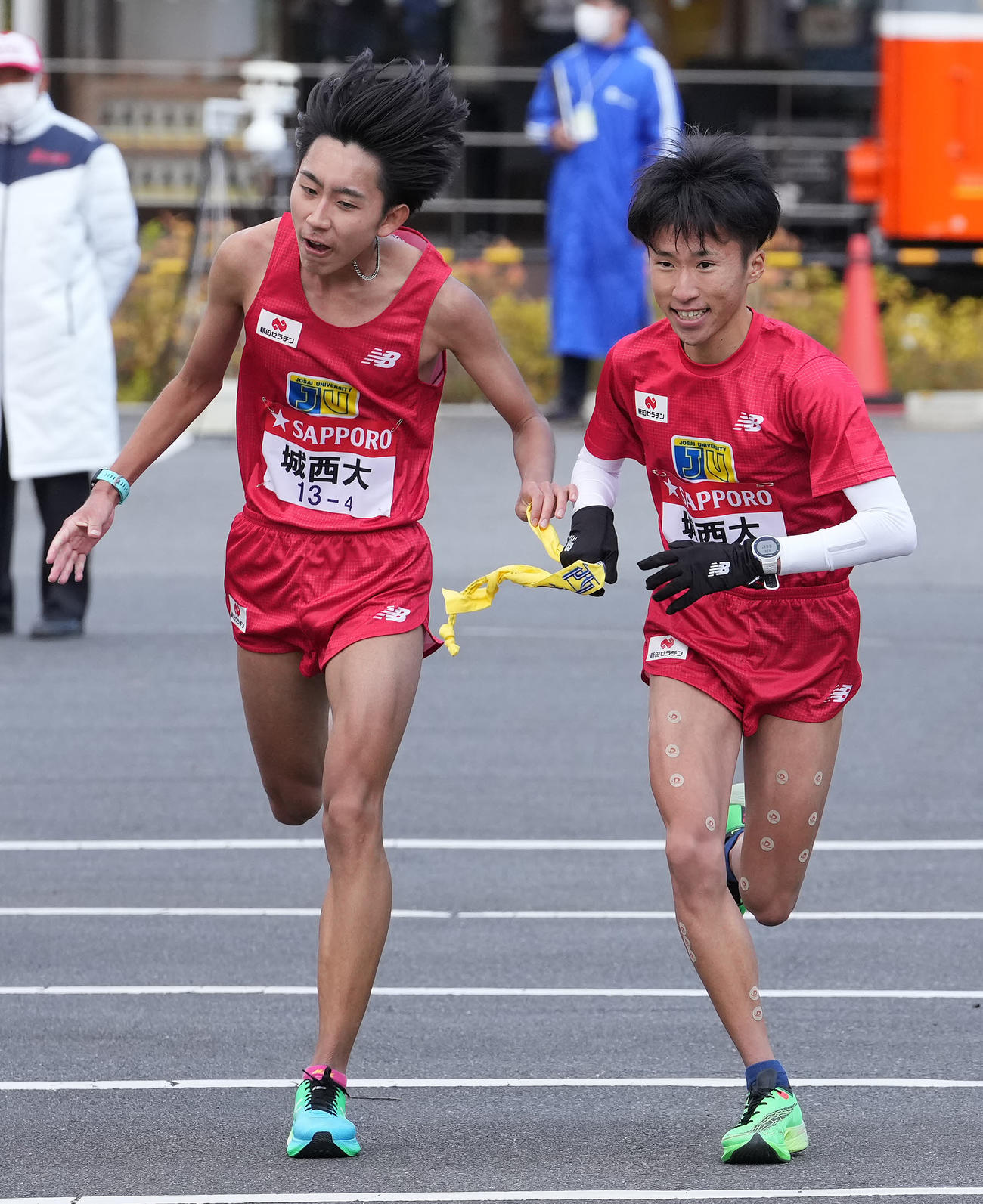 城西大4区鈴木（左）は小田原中継所で5区山本にたすきを渡す（撮影・鈴木みどり）