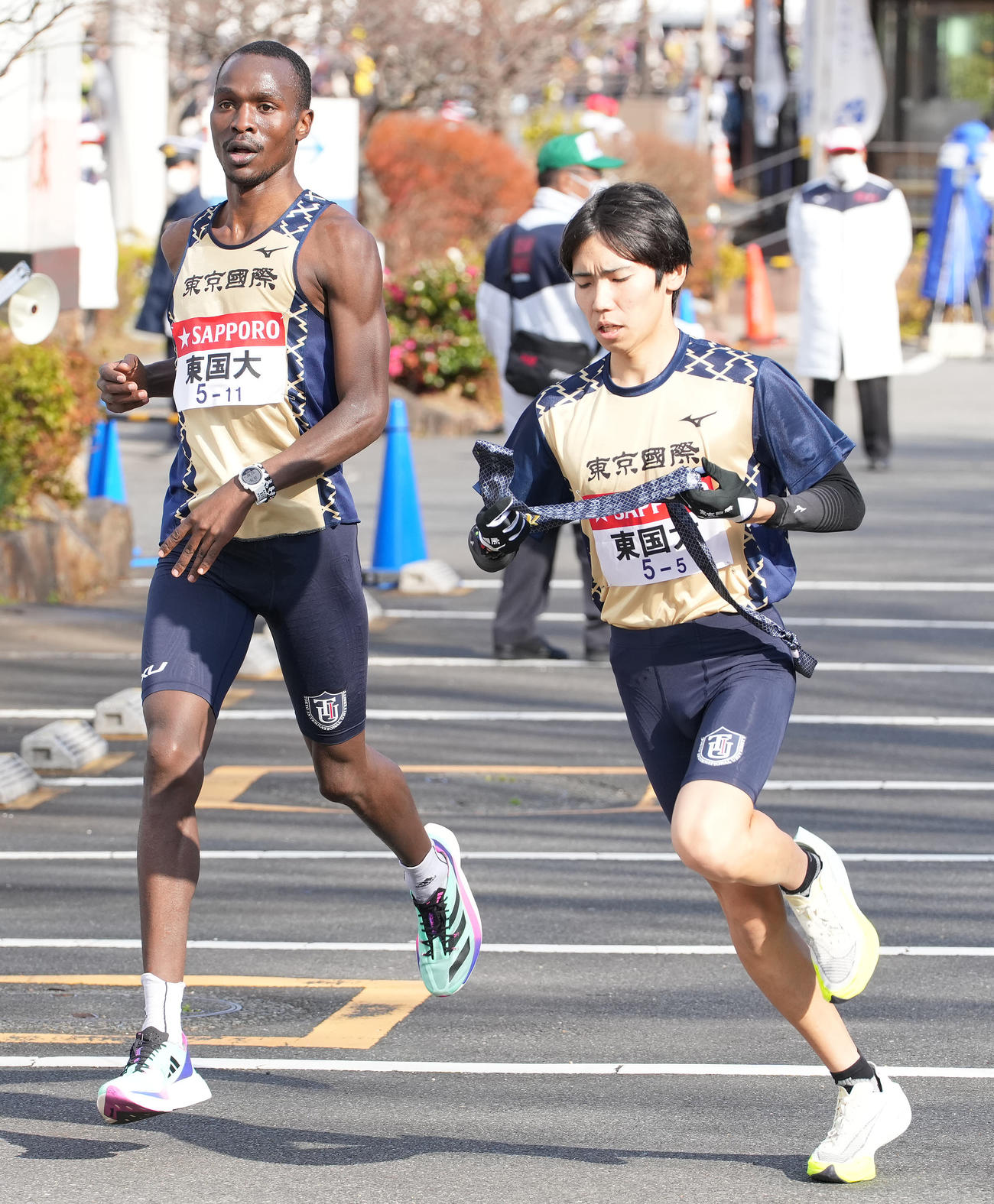 東京国際大4区ヴィンセント（左）は小田原中継所で5区川端にたすきを渡す（撮影・鈴木みどり）
