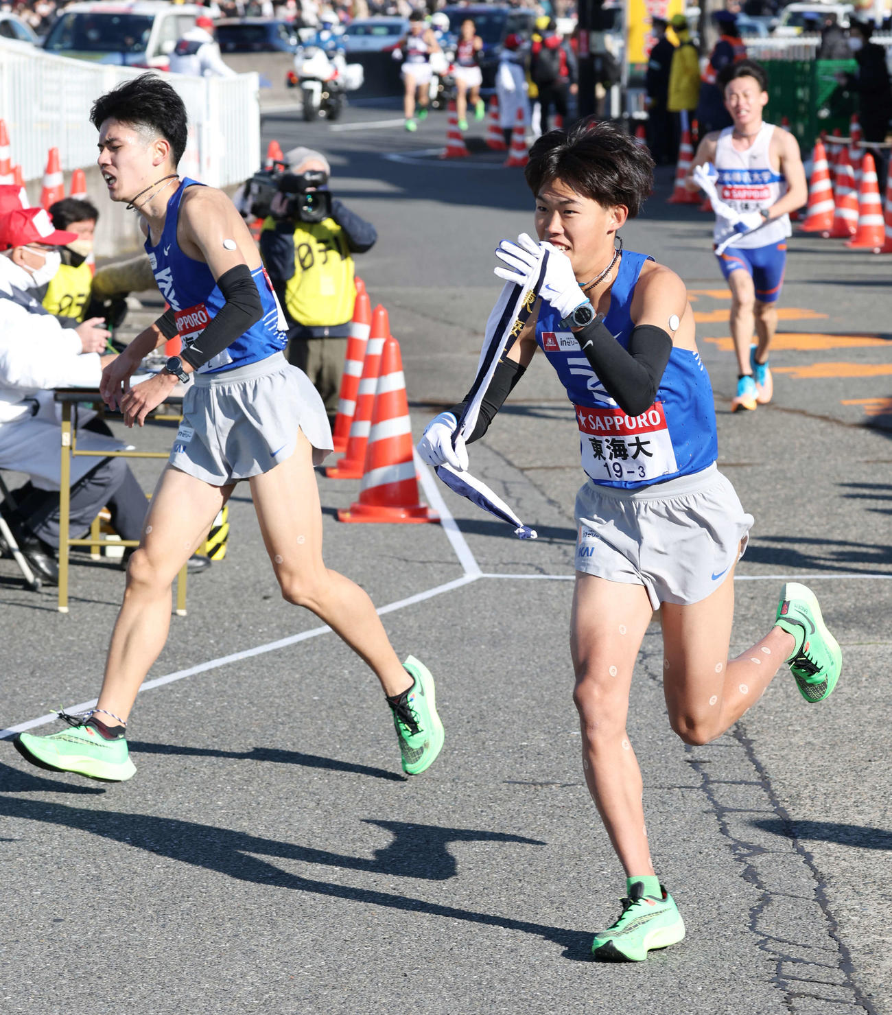 戸塚中継所で東海大2区石原（左）は3区花岡にたすきを渡した（撮影・宮地輝）