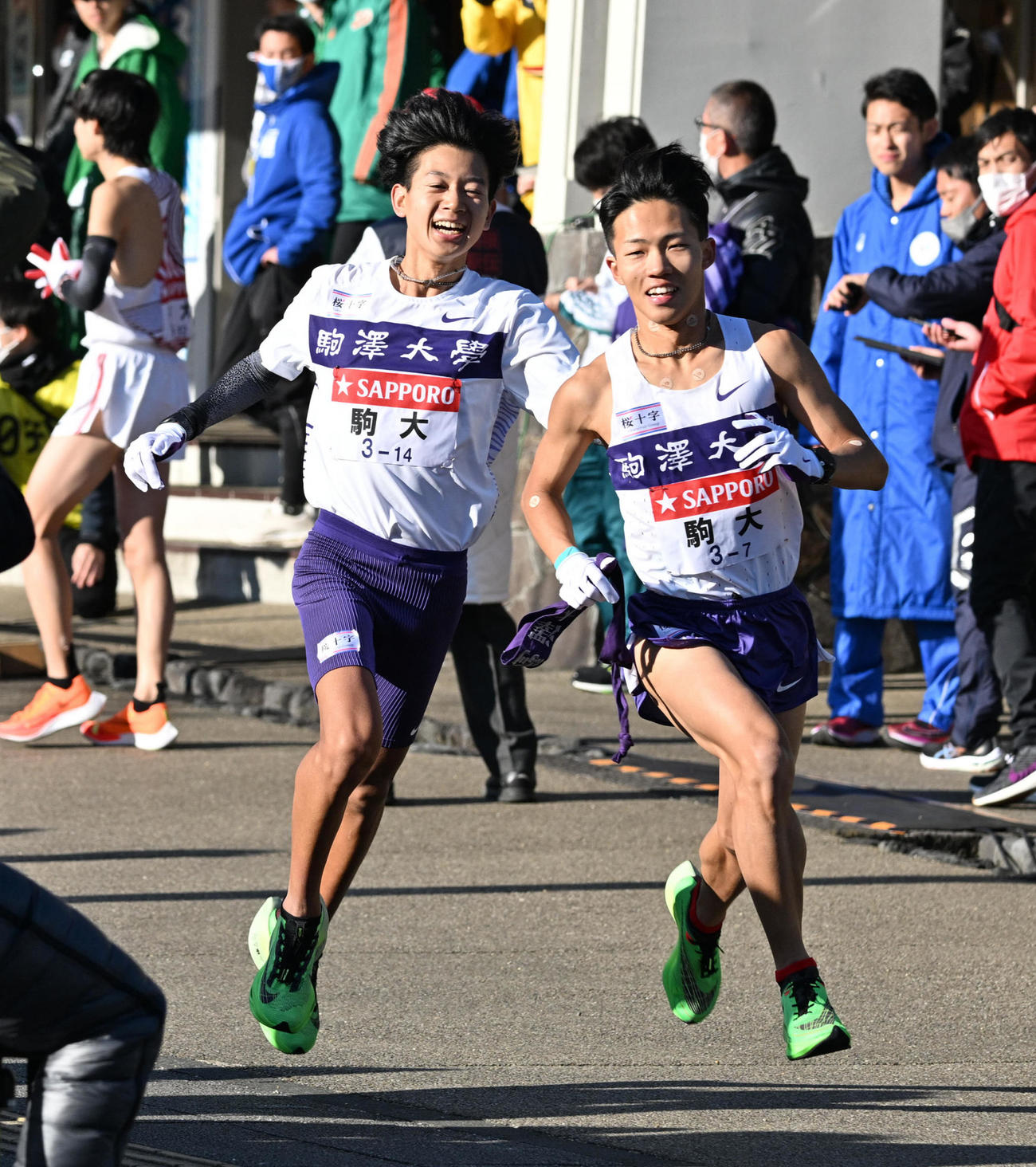 小田原中継所でたすきをつなぐ駒大6区の伊藤（左）と7区の安原（代表撮影）